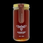 Jar of Banner Bee Artisan Honey with a gold lid on a white background